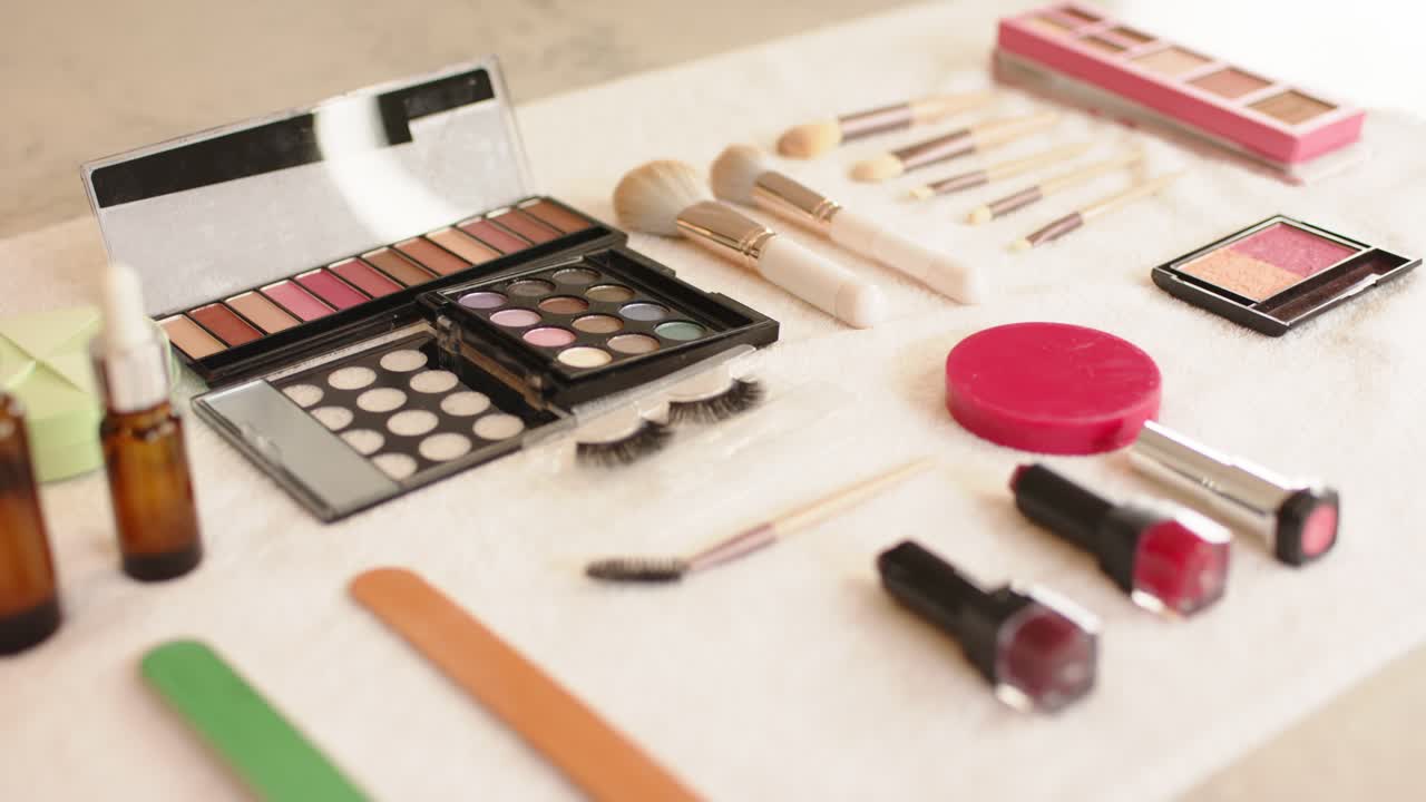 Camera is starting focus shift from amber bottles to lipsticks and is showcasing makeup collection