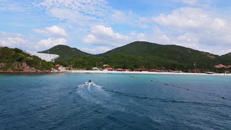 4k drone footage of a jet skier crushing the waves of the beautiful coastline of ko larn island in thailand