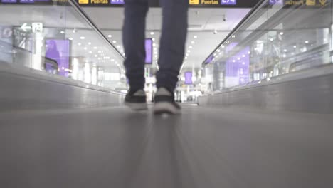 traveler walking through airport hall, low angle shot