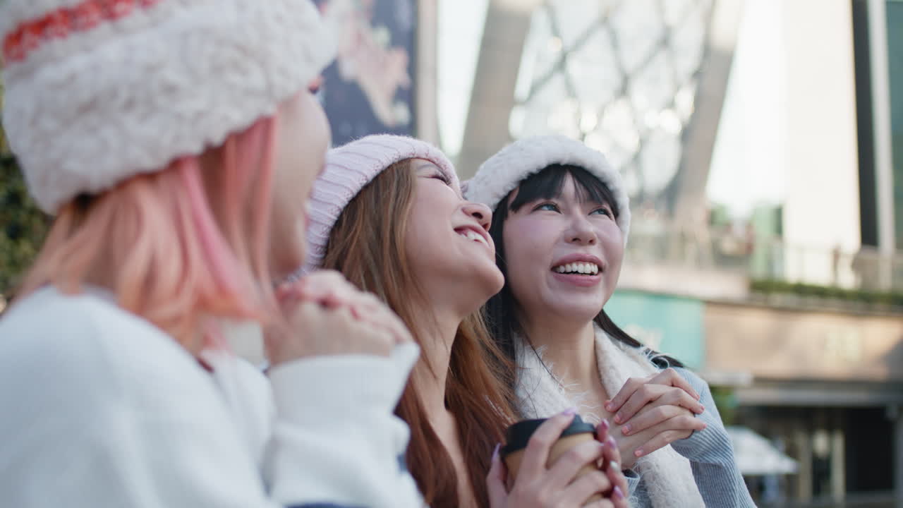Three smiling women wearing winter hats