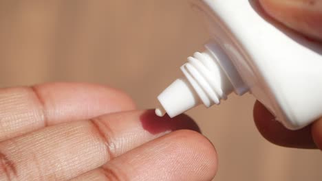 person applying sunscreen lotion on their hand