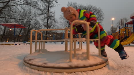 little child playing in the yard in winter evening