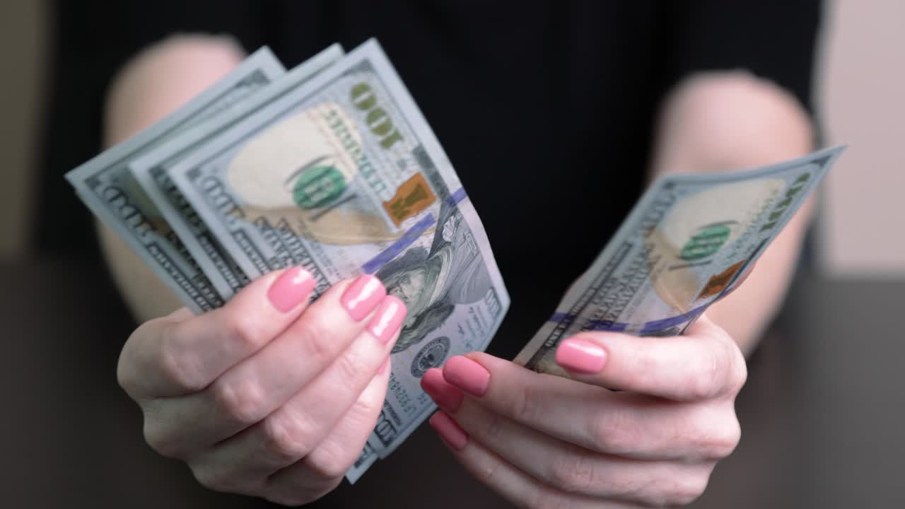 dólares en las manos de una mujer, la chica cuenta billetes, dinero de papel. presupuesto familiar, pago de facturas