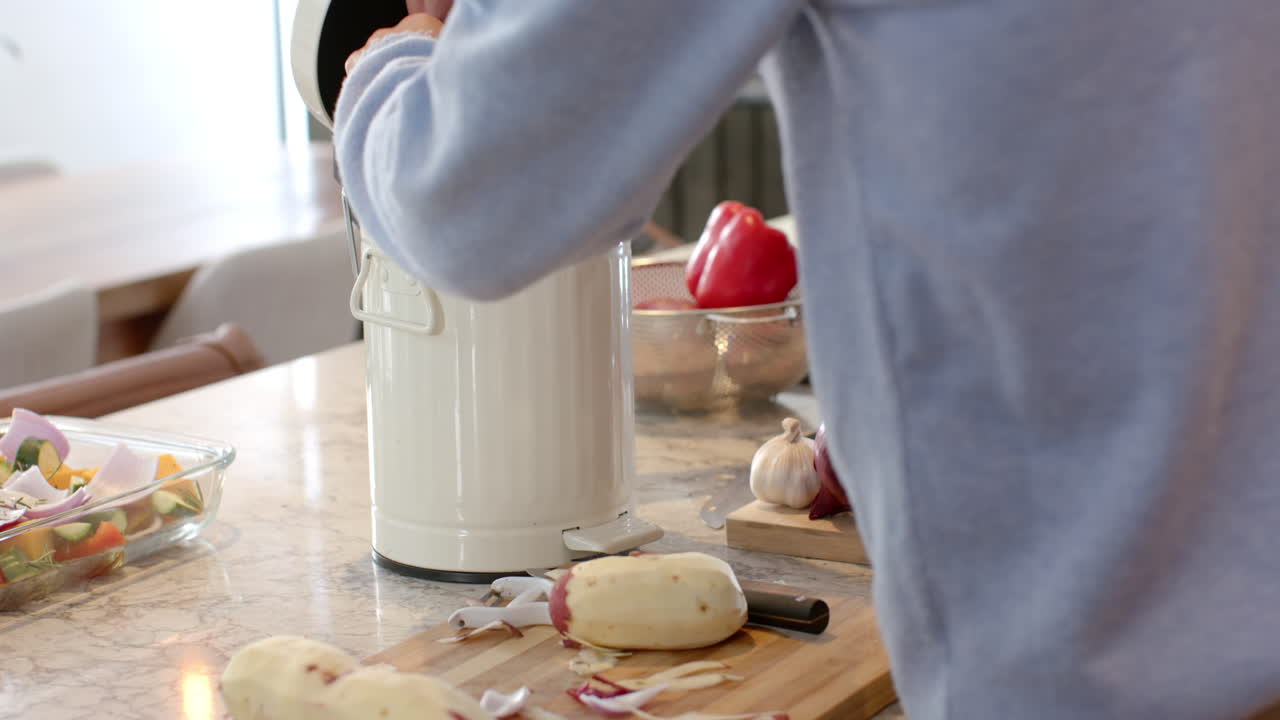 Peeling potatoes and preparing vegetables, person cooking in modern kitchen, at home