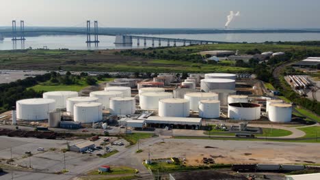 antena de tanques de almacenamiento de refinería de combustible de petróleo y gas en el puerto de wilmington usa, puente conmemorativo de delaware en la distancia