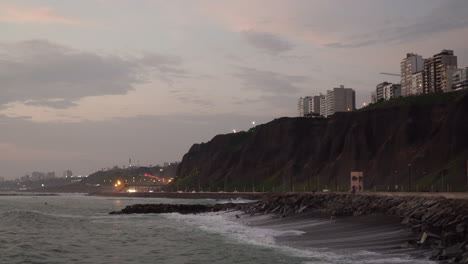 puesta de sol sobre el mar, carretera y edificios en el malecón de miraflores, lima, per?