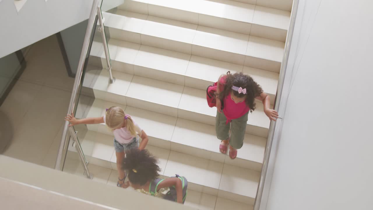 Video af mangfoldige piger, der går ned ad trappen i skolen, set oppefra.