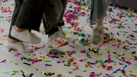 Kids&#039; sneakers over colorful confetti
