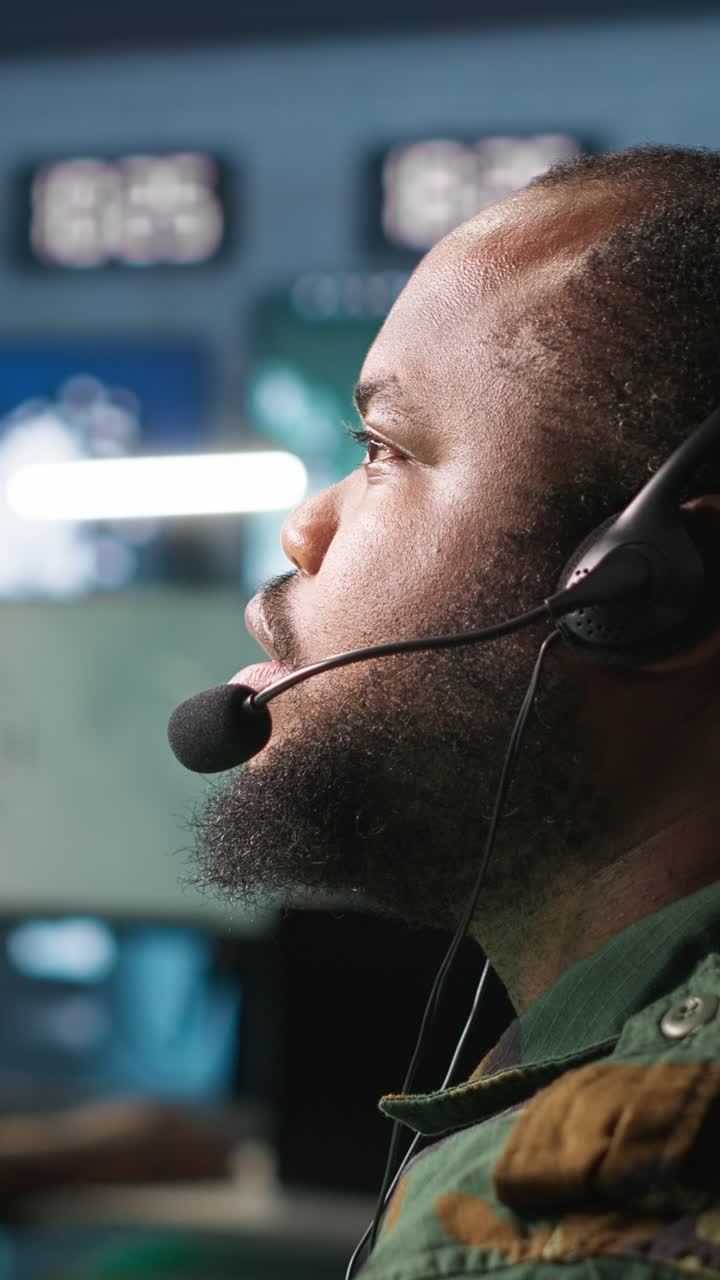 Vertical video Military dispatcher managing communications networks, looking at screens