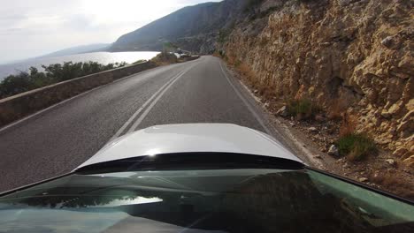 Hermoso-Conductor-Pov-En-Una-Carretera-Costera-Del-Golf-De-Corinto-En-Grecia-Con-Luz-Solar-Brillante-Brillando-En-El-Agua-De-Mar