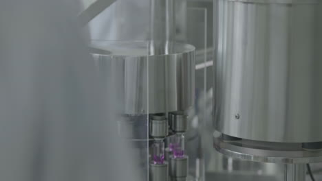 scientists or technicians in protective control medical vials filled with liquid on a production line in a pharmaceutical factory, showcasing modern medicine laboratory science.
