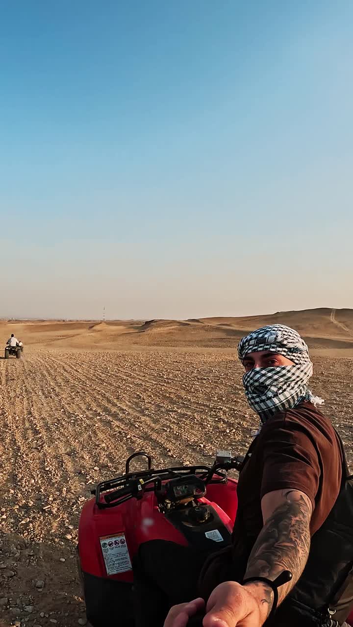 Persona in quad nel deserto con altri piloti