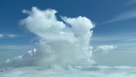 punto de vista único del piloto tomado desde la cabina de un jet que vuela hacia un diminuto cúmulo que se desvanece a 10000 m de altura
