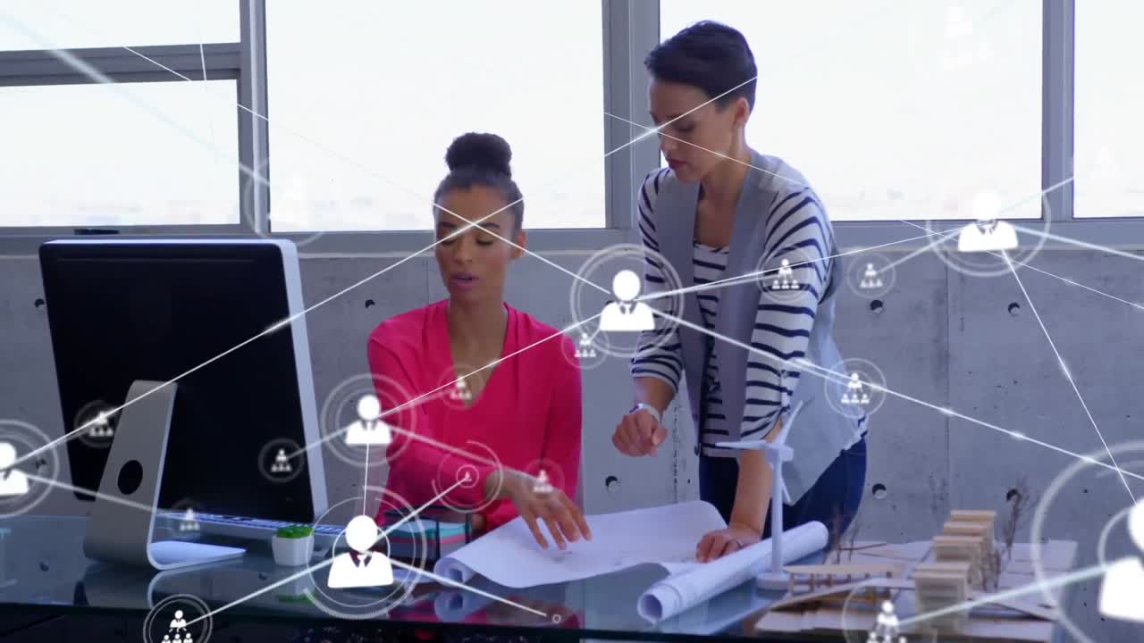 animación de una red de iconos digitales sobre dos mujeres diversas discutiendo un plan en la oficina
