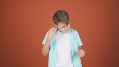 chico haciendo señas de rocker y bailando.
