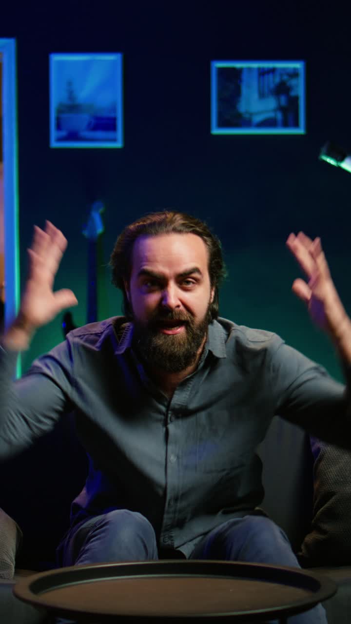 Vertical video Irked supporter raging while watching sports broadcast, throwing pillow at TV