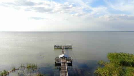 flying above a florida lakeside dock on a beautiful, clam, spring evening