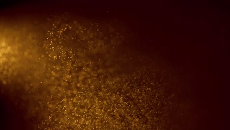 golden particles float in the air, magic background. blurred bokeh background of gold dust particles slowly floating in the air