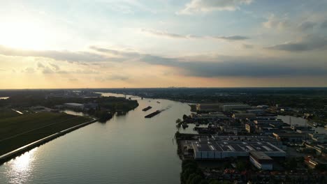 Silhouette-Von-Zwei-Booten,-Die-Entlang-Beneden-Merwede-In-Der-Ferne-Mit-Goldenem-Orangefarbenem-Sonnenuntergangshimmel-Segeln