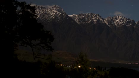 snow-capped mountains under a starry sky with silhouetted trees. subtle lighting creates a serene, nighttime landscape