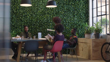 jóvenes empresarios negros se reúnen líder de equipo mujer compartiendo documentos corporativos colegas trabajando juntos en proyectos creativos lluvia de ideas en la oficina de moda