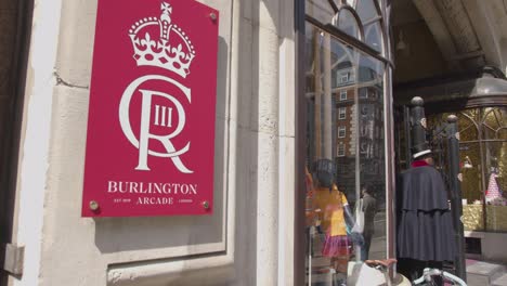 Sign-Outside-Burlington-Arcade-With-Shoppers-In-Mayfair-London-UK