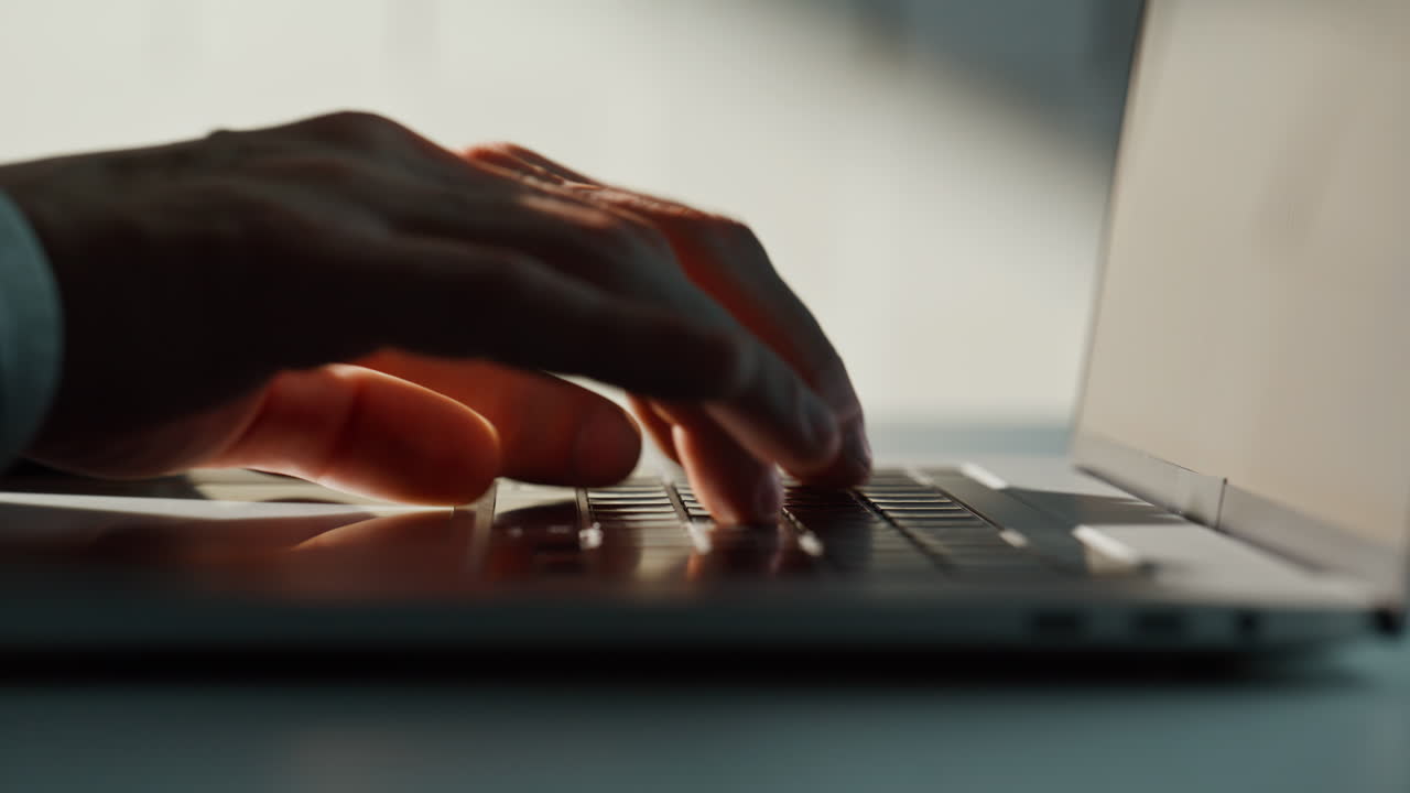 Businessman hands writing email on laptop at corporate office space closeup