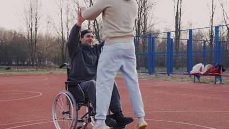 young disabled man playing to basketball with his friend 1