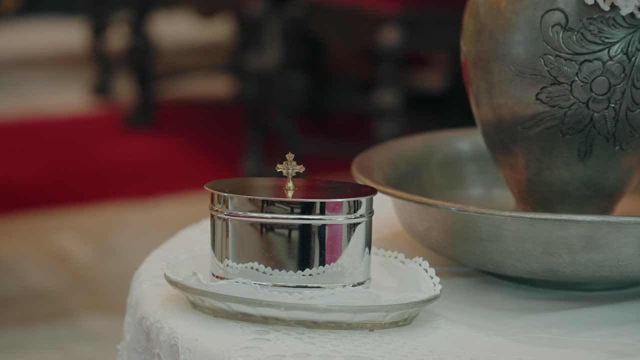 Close view of silver holy water vessel arranged for sacred ceremony