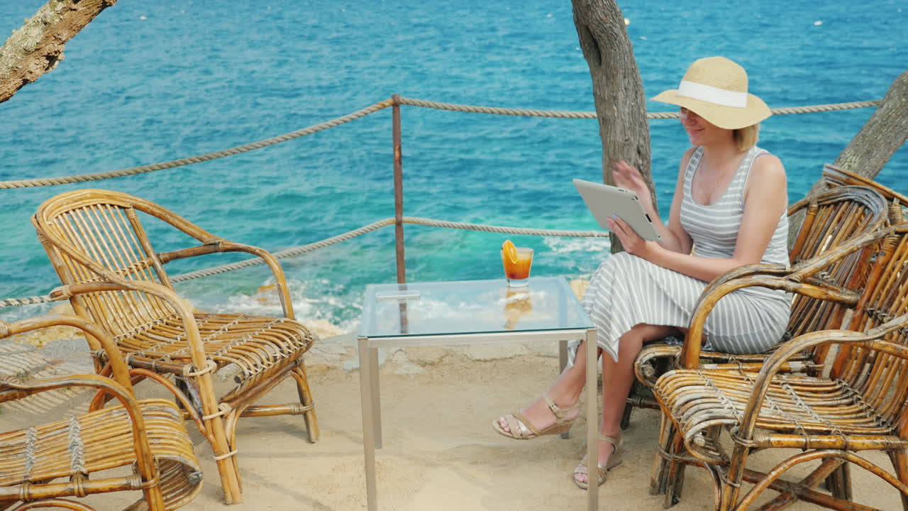 열대 리조트의 휴일은 항상 태블릿과 이야기하는 여성과 연결되어 있습니다.