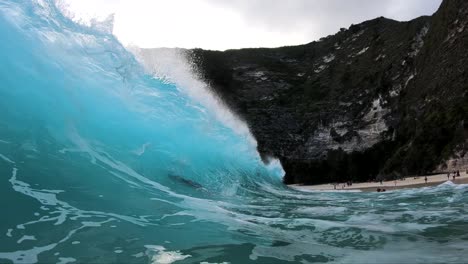toma en cámara lenta extrema de estar dentro del barril de una gran ola en la playa de kelingking, en la isla de nusa penida, bali, indonesia