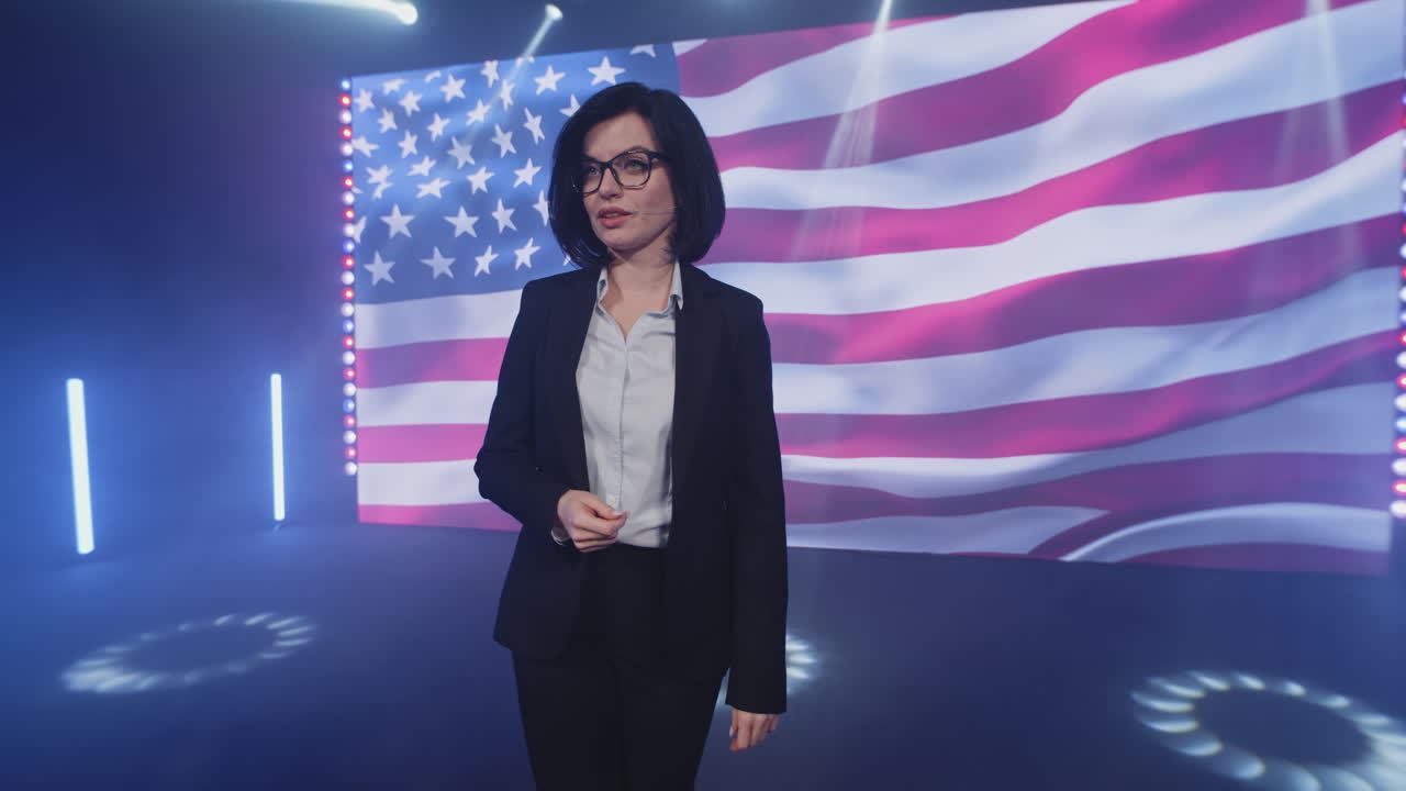 Woman Speaker Presenting on Stage with American Flag Background