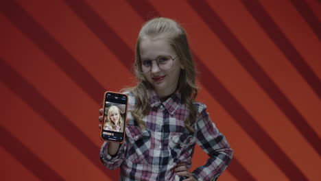 girl with glasses taking selfie with smartphone