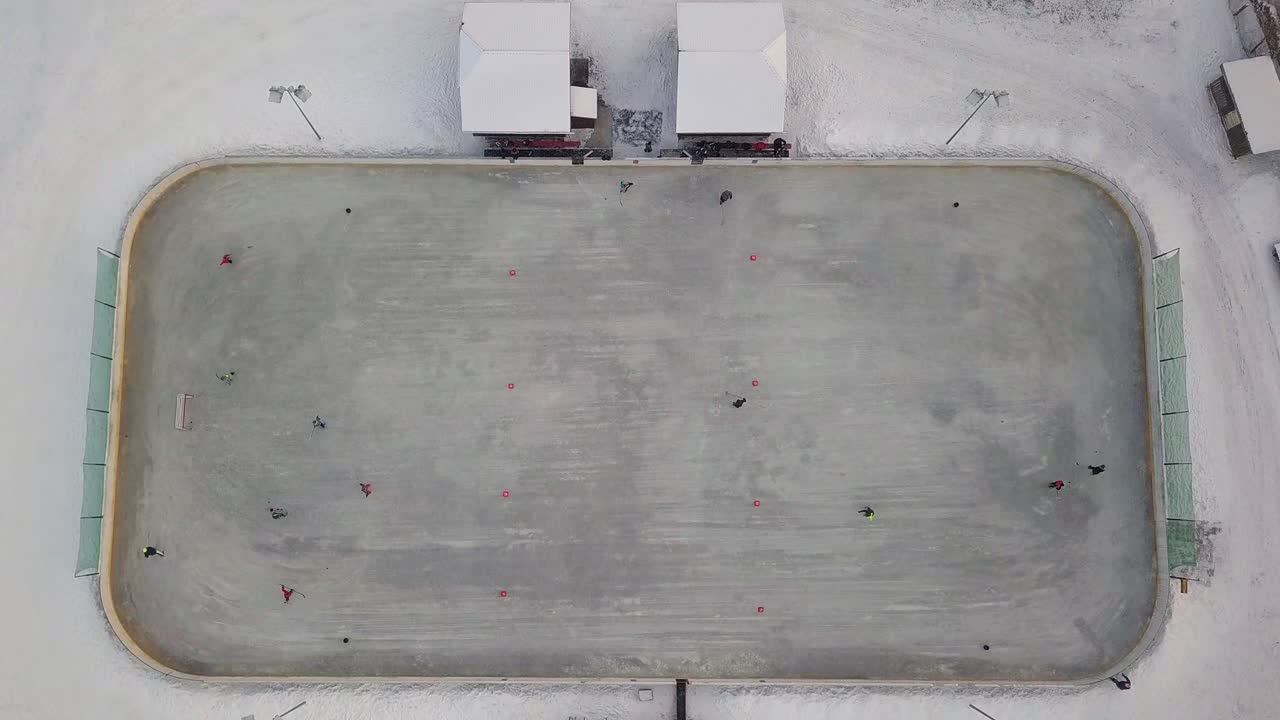 práctica amateur de hockey sobre hielo en el campo local - vista de drones de arriba hacia abajo, descendiendo