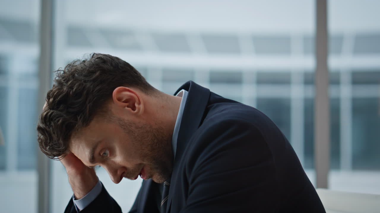 Focused businessman reviewing documents in office feeling tension closeup