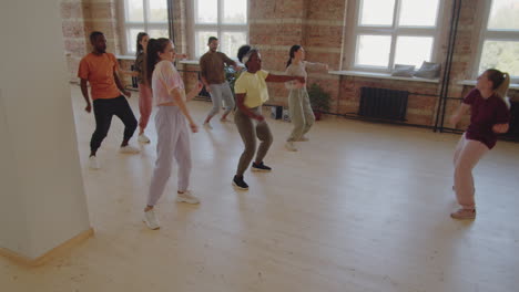 young diverse students learning dance with female teacher