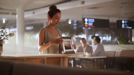 woman framing a picture in a modern indoor setting