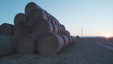 las balas de heno, apiladas en una pirámide, secas en el campo al atardecer.