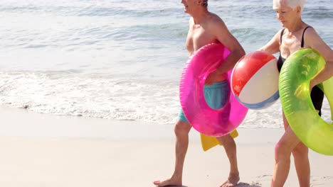 smiling couple holding beach equipment