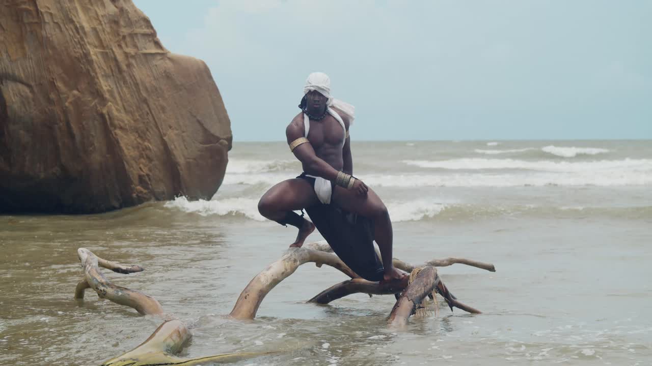 A muscular male cosplayer with dark skin at the beach.