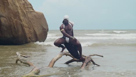 a muscular male cosplayer with dark skin at the beach.