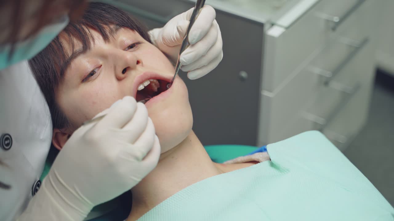 Female dentist working in her dentist office. Dental clinic. Reception, examination of the patient.