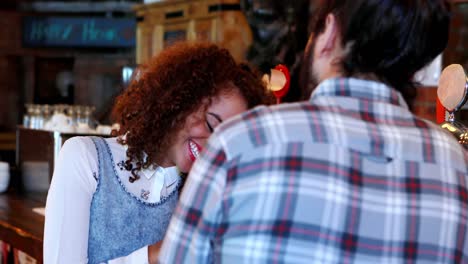 Couple-interacting-with-each-other-at-bar-counter