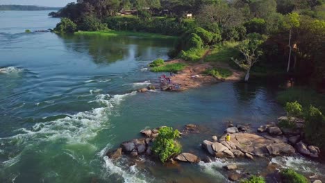 aerial drone shot of the river nile in uganda, africa, showcasing the river's rapids, rocks, lush vegetation, and the source area of the mighty river