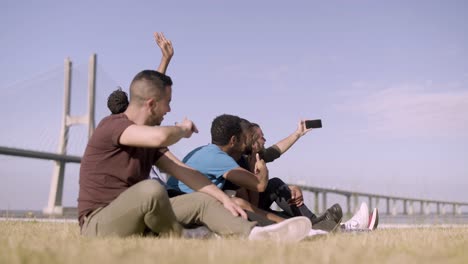 Amigos-Sonrientes-Haciendo-Gestos-Mientras-Se-Toman-Autorretratos-Con-Un-Teléfono-Inteligente