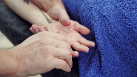 male massagist doing healthcare massage on the female's hand. close-up man's hand massaging woman's fingers. body care concept