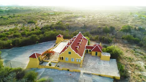 Landhuis-brievengat-yellow-siding-with-red-prominent-roof-establishing-entertainment-center