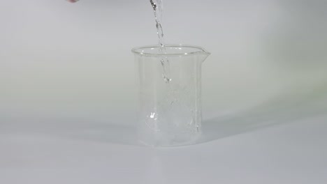 water being poured into a beaker with ice