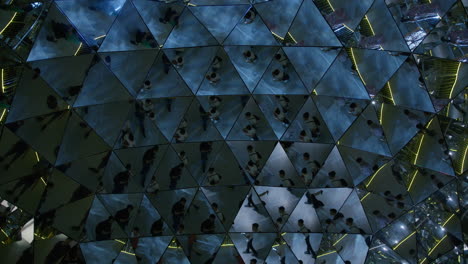 people walking through a mirrored maze