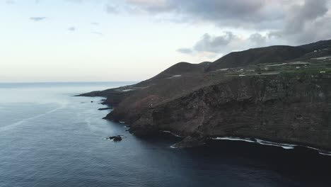 Drone-shot-rugged-sea-cliffs-on-Canary-Island,-Spain,-with-clouds-in-the-sky